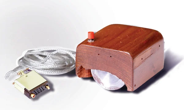 The wooden mouse in three-quarter view with its braided cable and connector laid out beside it.